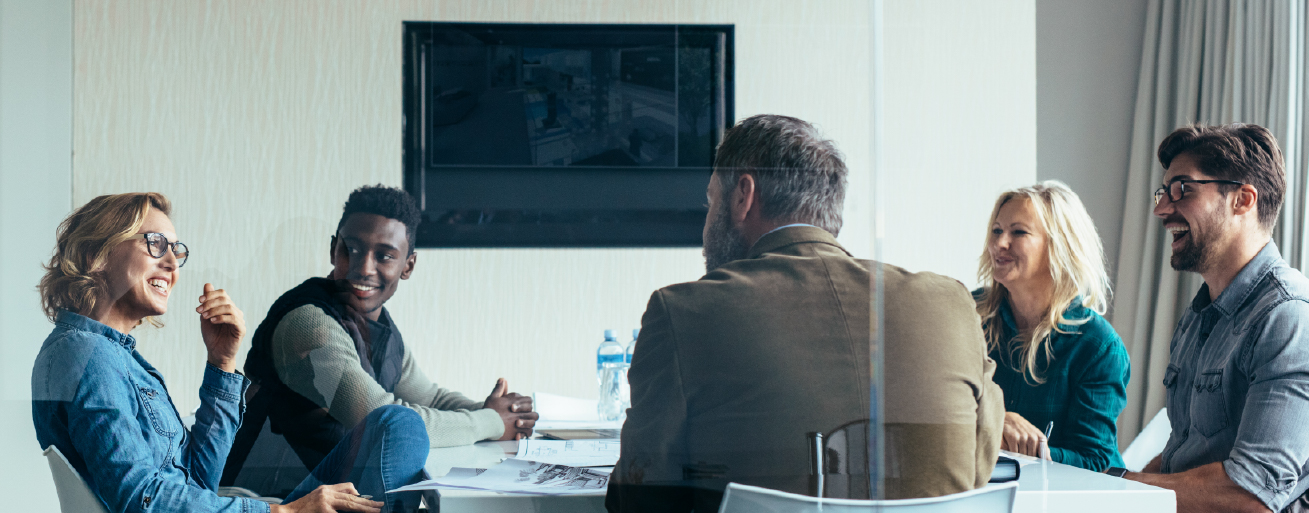 A group of executives sitting around a table in a conference room discussing the advantages of expanding a business internationally